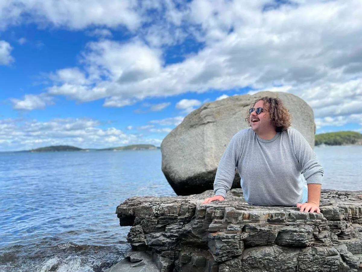 My brother posing as a mermaid on a rock outcropping above the ocean.