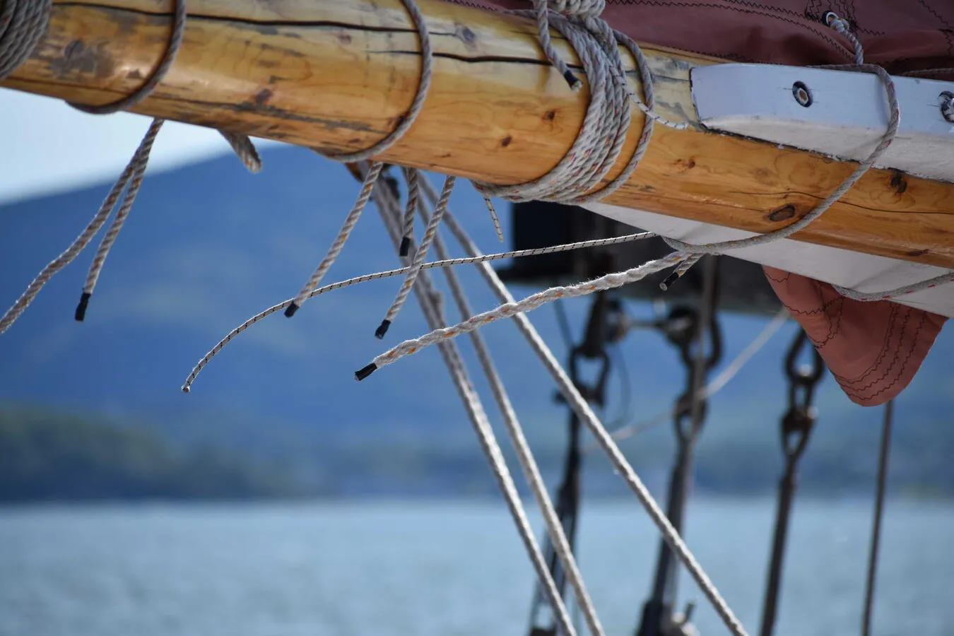An artistic, zoomed in photo of a schooner's mast and some of its rigging.